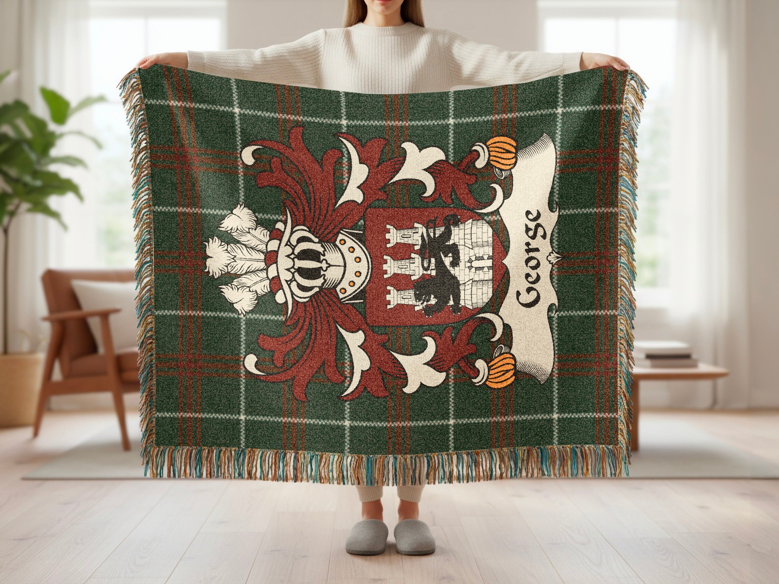 Green tartan throw blanket with a heraldic crest and "George" embroidered.