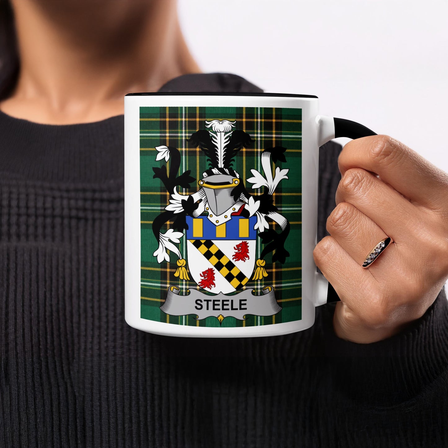 White mug with black rim featuring the Steele family crest on a tartan background.