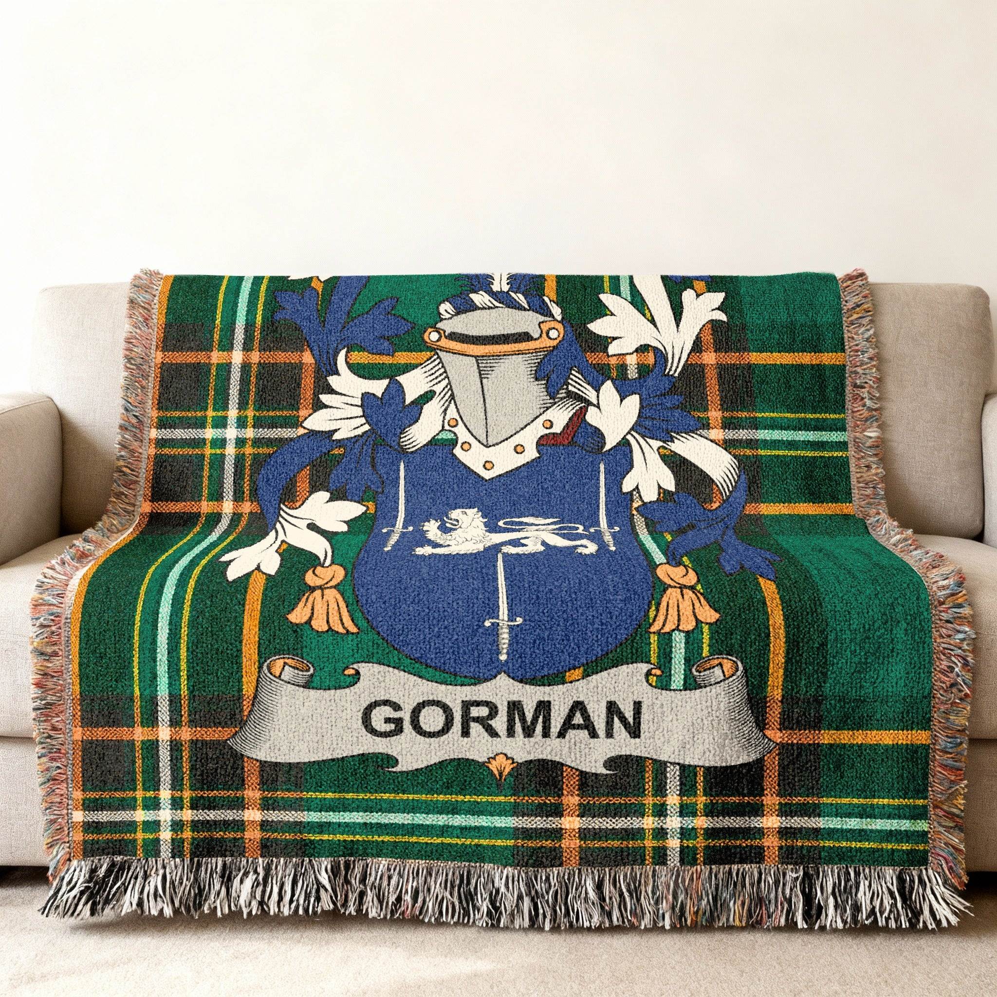 Green plaid blanket with a blue and silver coat of arms and the name GORMAN.