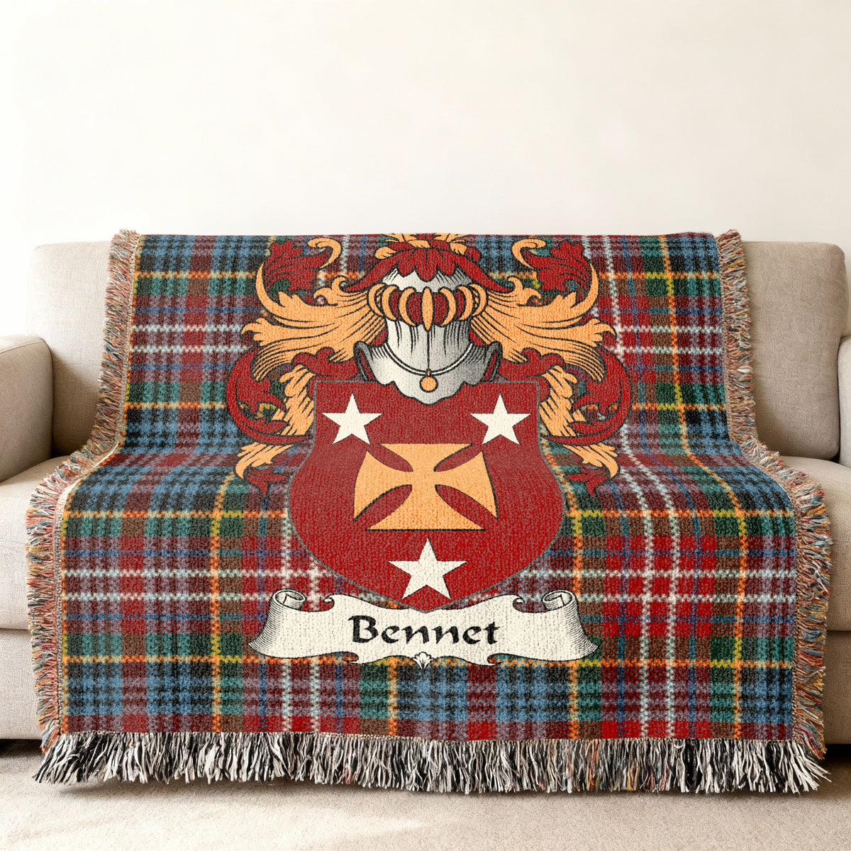 Bennet Scottish family shield woven blanket with Caledonia tartan background on a sofa