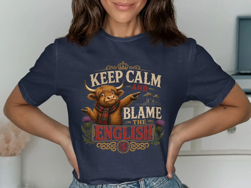 Navy t-shirt with "Keep Calm and Blame the English" text and highland cow graphic.