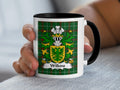 White mug with Wilkins coat of arms on green tartan background.