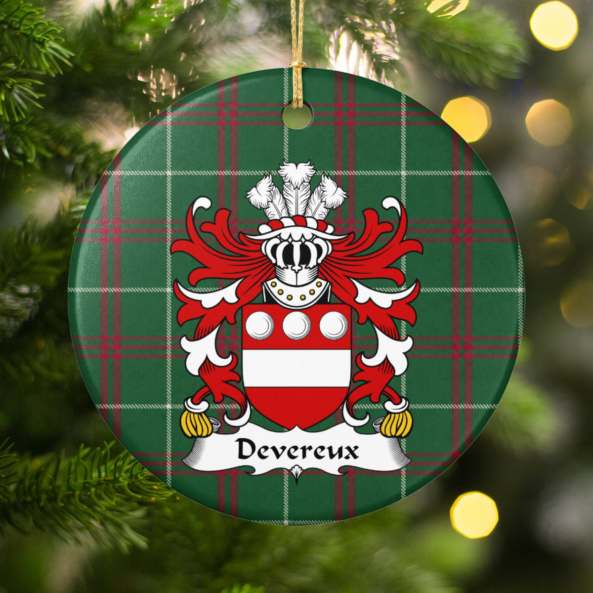 Devereux ornament hanging among Christmas tree branches and warm lights; three white roundels above a white horizontal band on a red shield on Welsh national tartan.