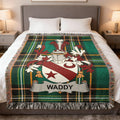 Green plaid blanket with a Waddy family crest centered on it.