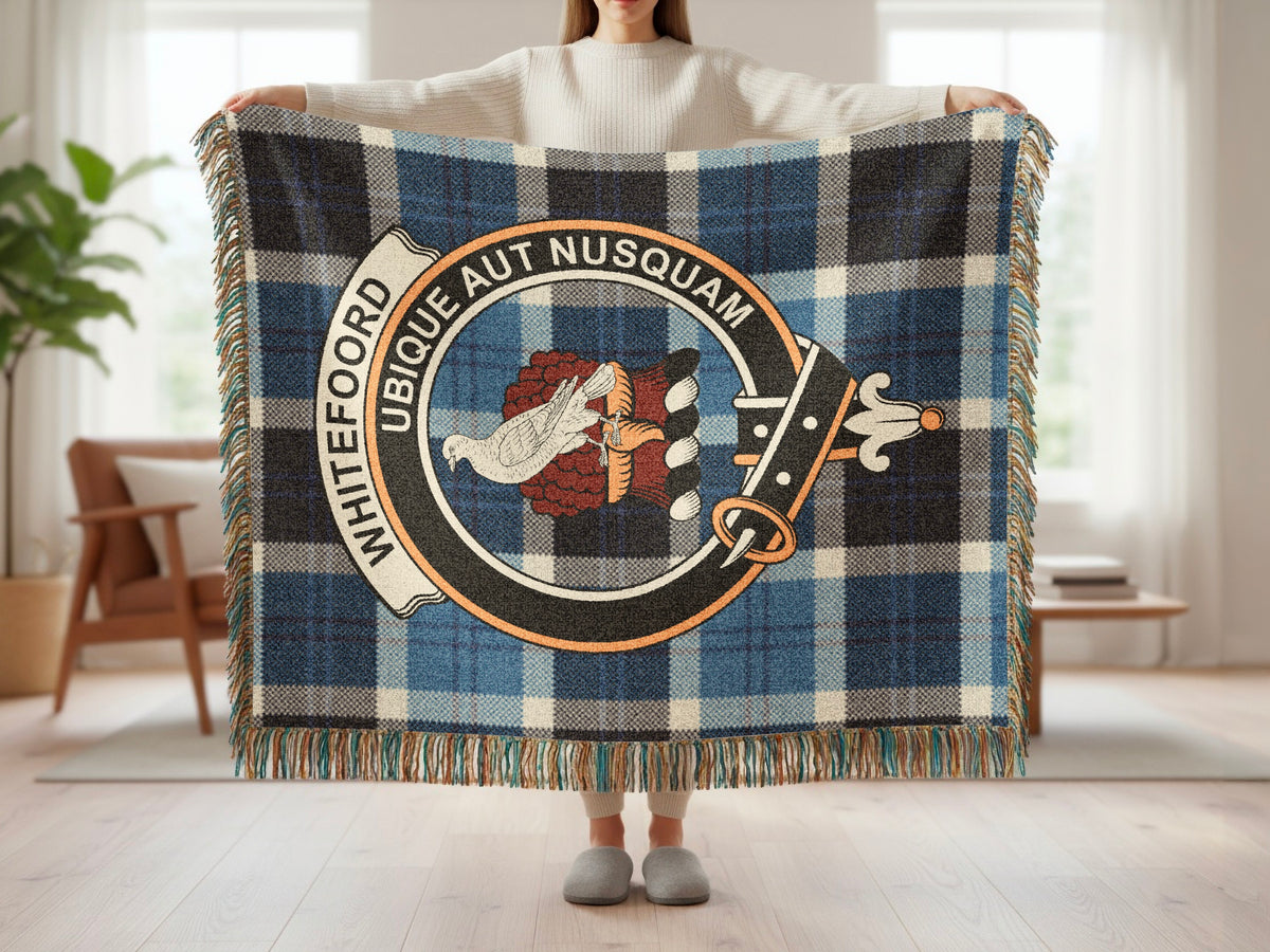 Person holding the Whitefoord woven blanket to show the full design, tartan background and fringe