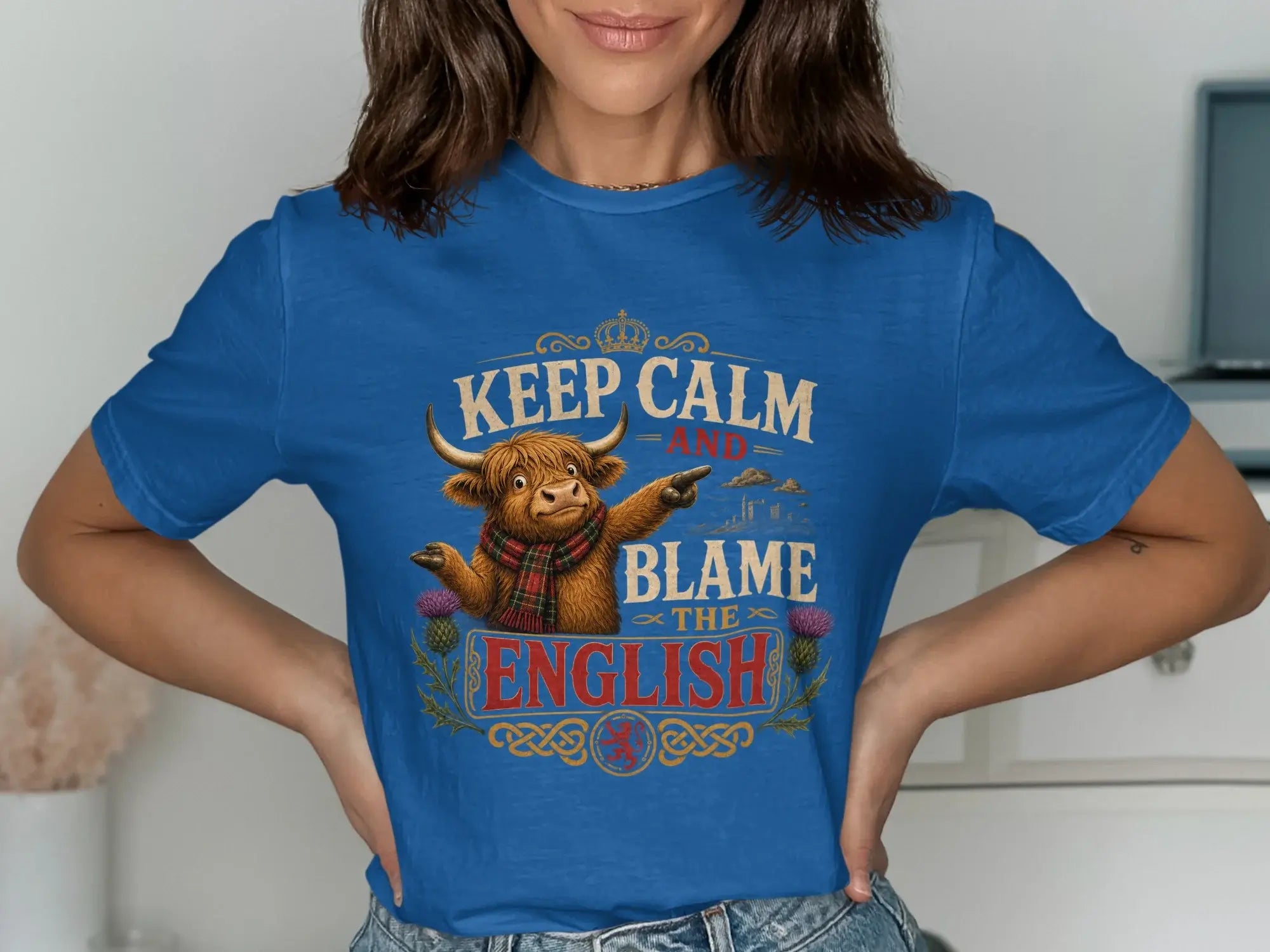Blue t-shirt with a Scottish bull wearing a tartan scarf and text "Keep Calm and Blame the English".