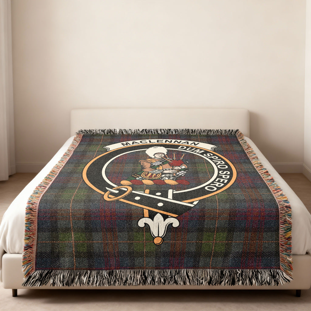MacLennan Scottish woven blanket spread across a bed, showing the full crest design and tartan background