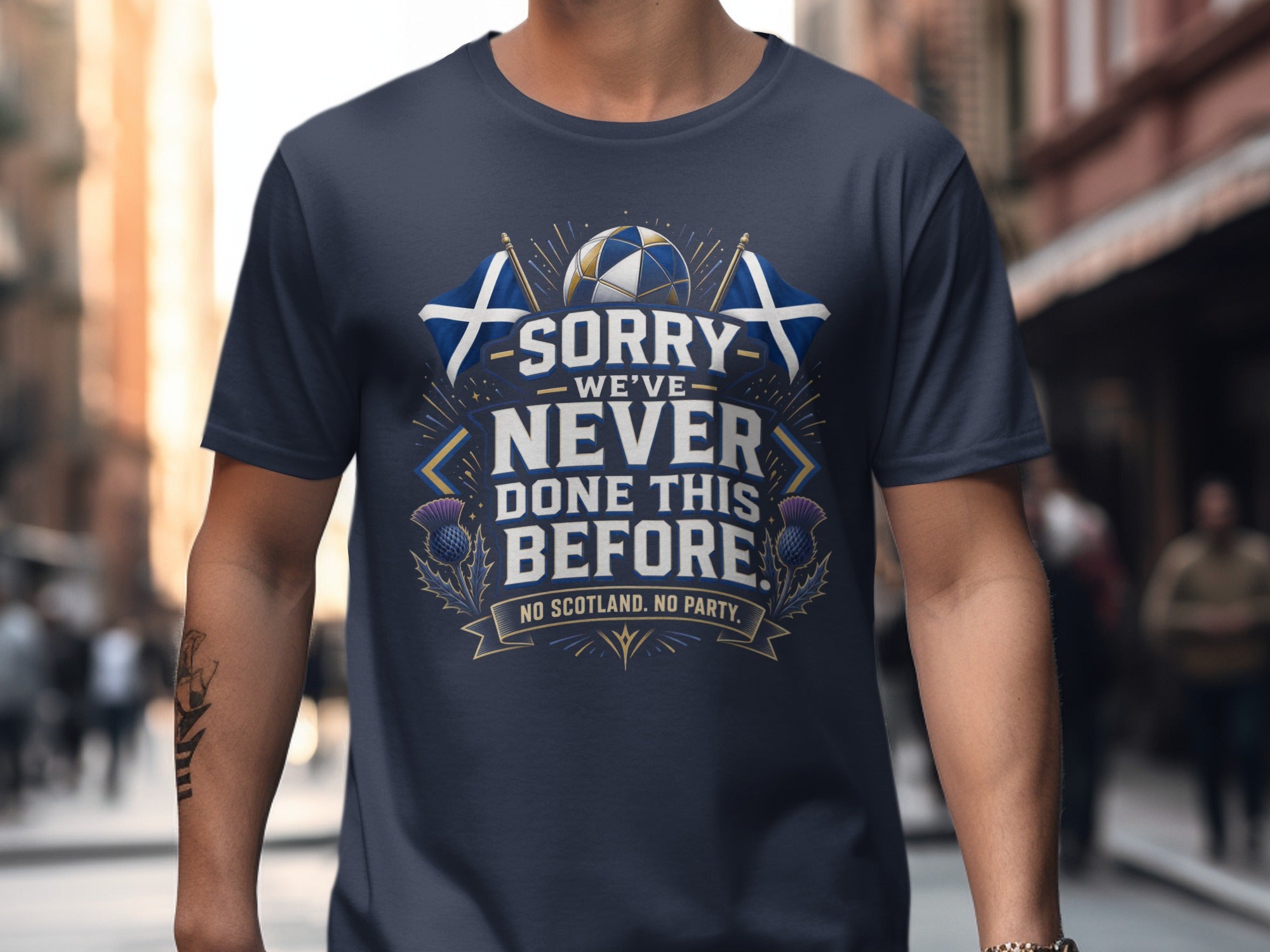 Navy t-shirt with Scottish flags, thistle, and text "WE'VE NEVER DONE THIS BEFORE. NO SCOTLAND. NO PARTY."