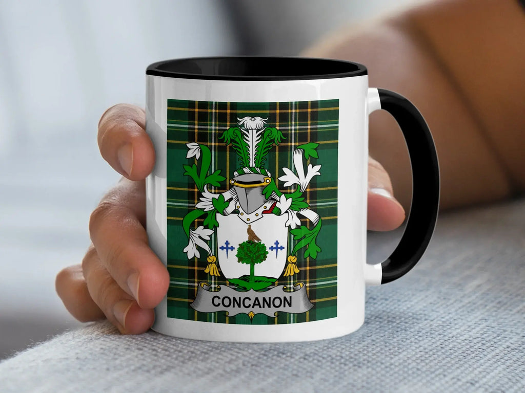 White mug with black rim featuring a green tartan shield and the name "CONCANON".