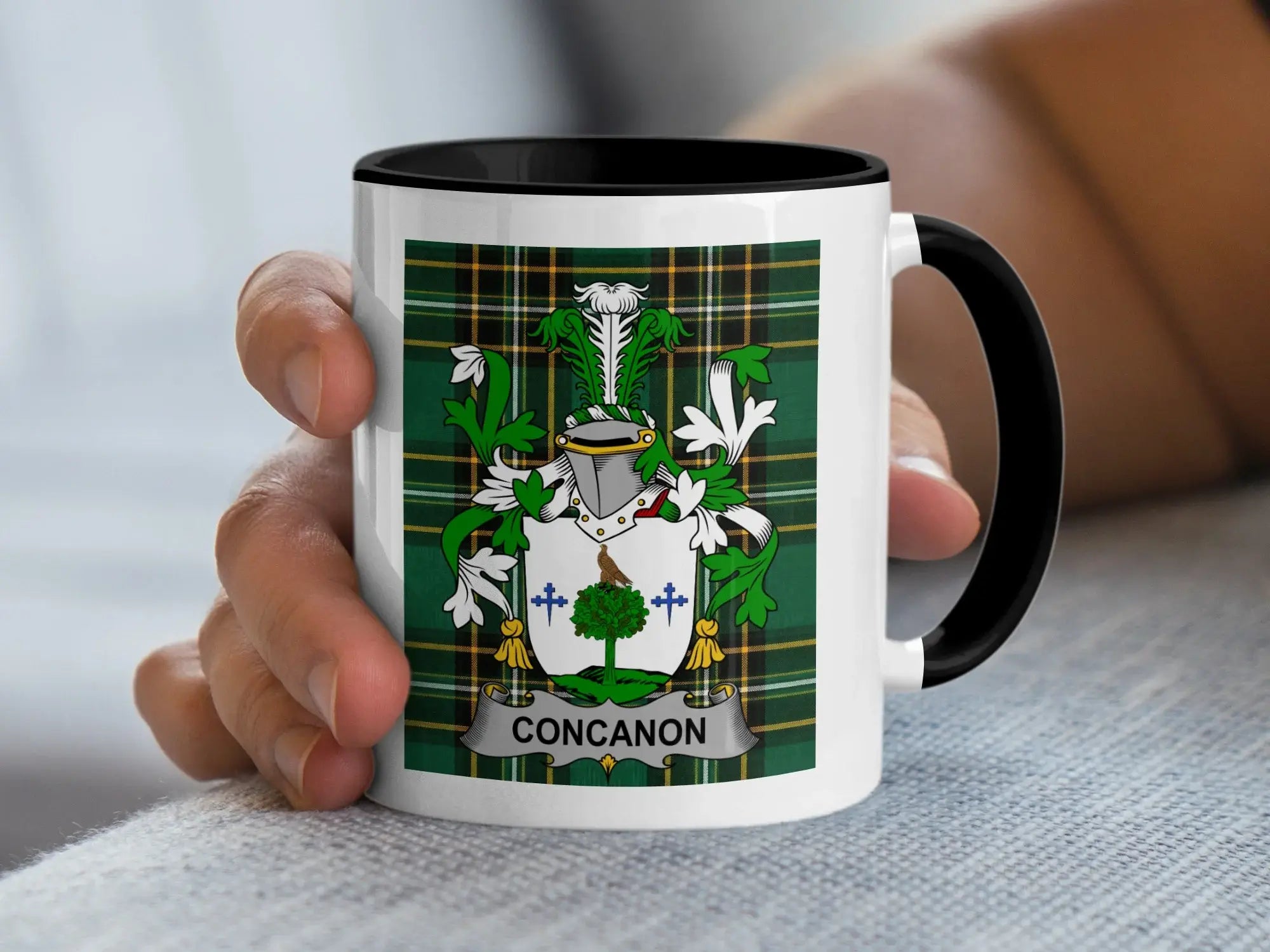 White mug with black rim featuring a green tartan shield and the name "CONCANON".