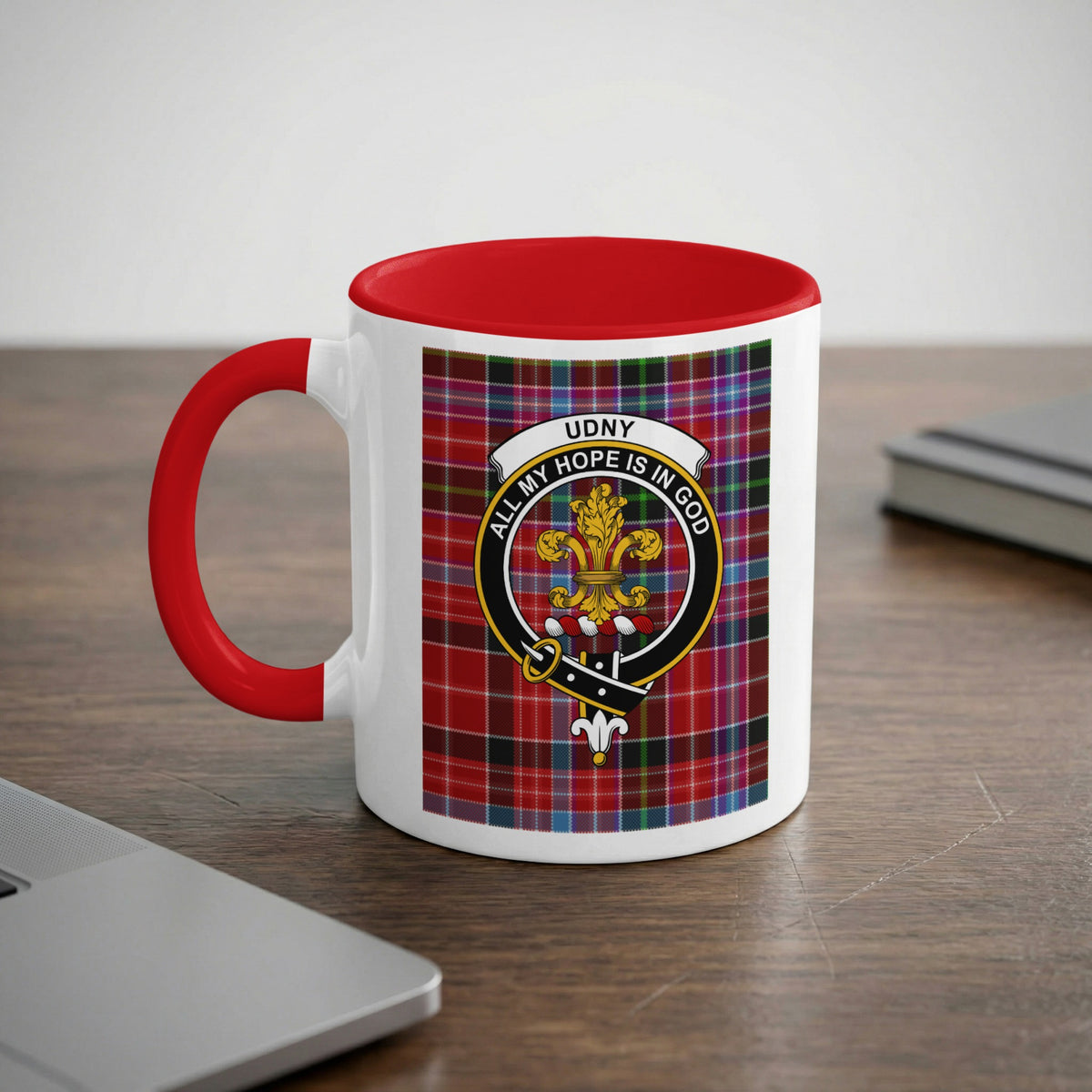 Udny Scottish family crest artwork on an 11 oz red accent mug with a tartan background