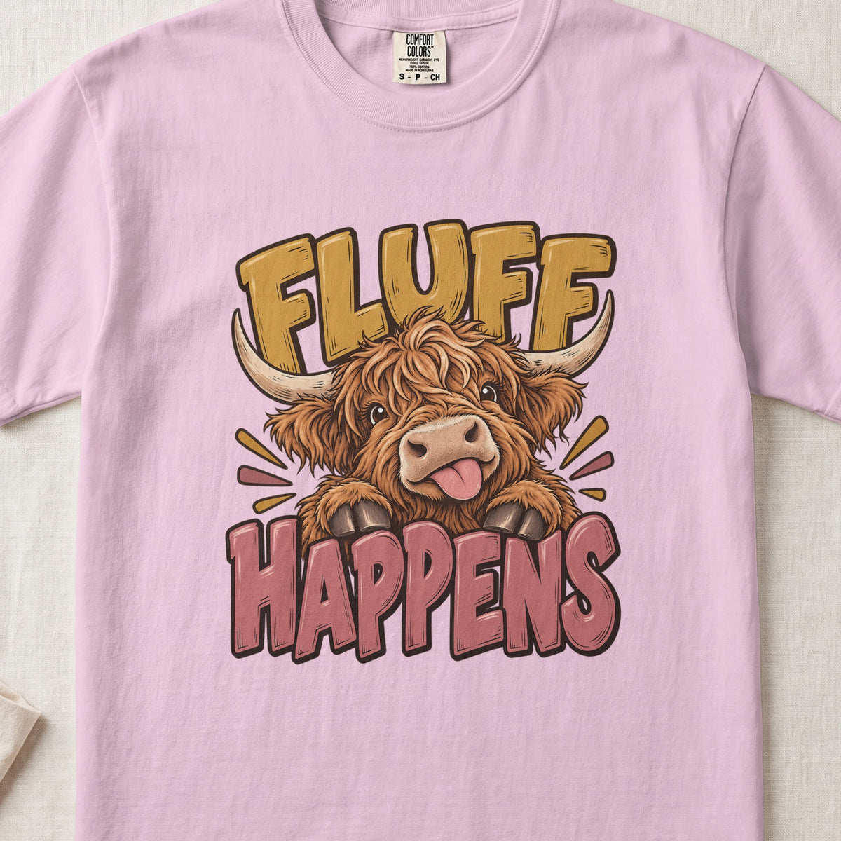 Fluff Happens Highland cow design on a Blossom Comfort Colors 1717 T-shirt, flat lay