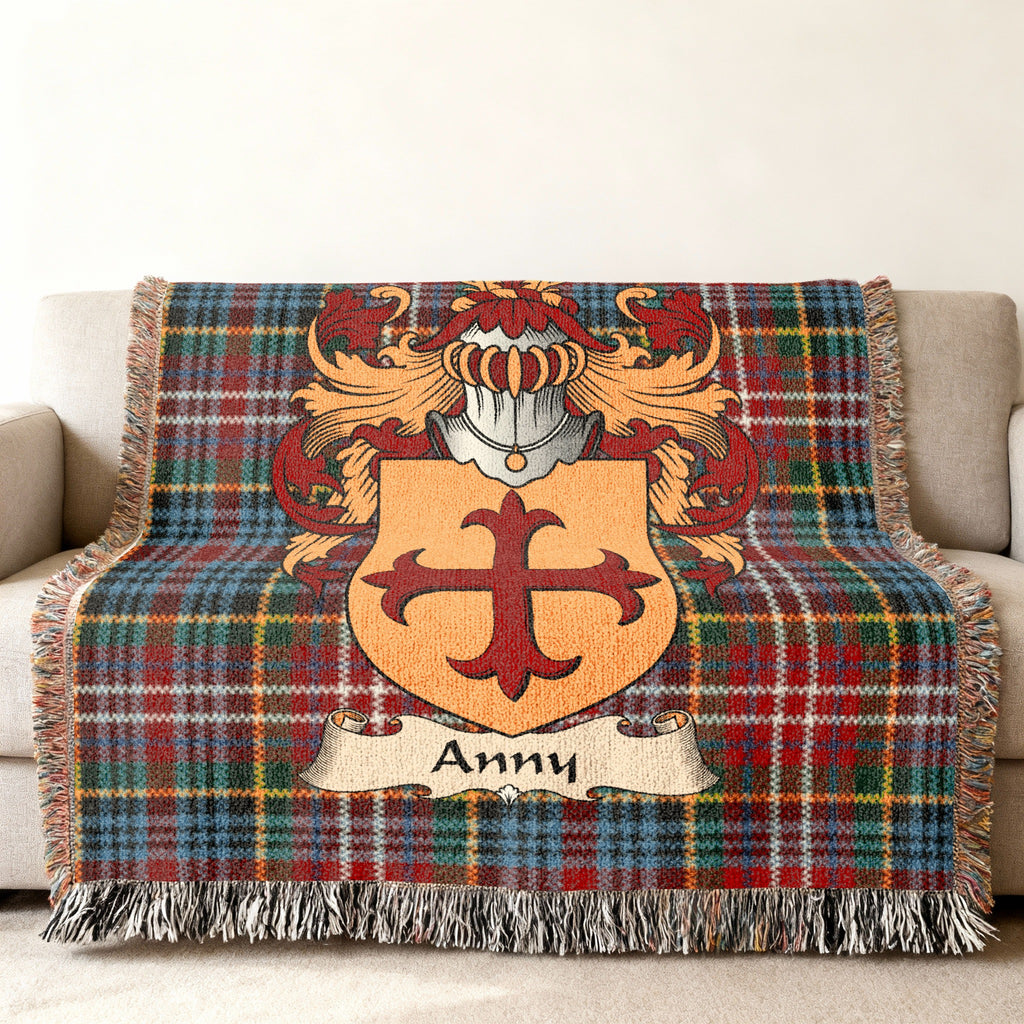 Anny Scottish family shield woven blanket with Caledonia tartan background on a sofa