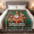 Tartan blanket with Quartermaines crest centered on a bed.