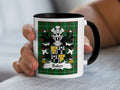 White mug with black handle featuring Baker family crest on green plaid background.