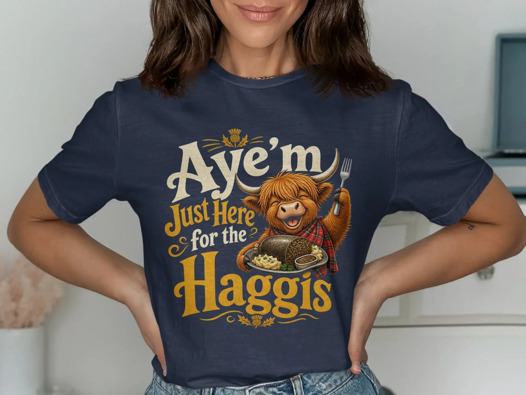 T-shirt with Highland cow wearing scarf, holding fork, with "Aye'm Just Here for the Haggis" text.