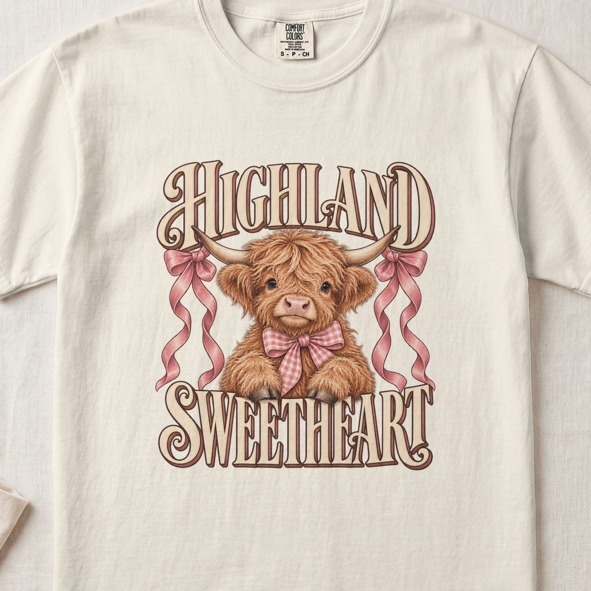 Highland Sweetheart Highland cow design on an Ivory Comfort Colors 1717 T-shirt, flat lay