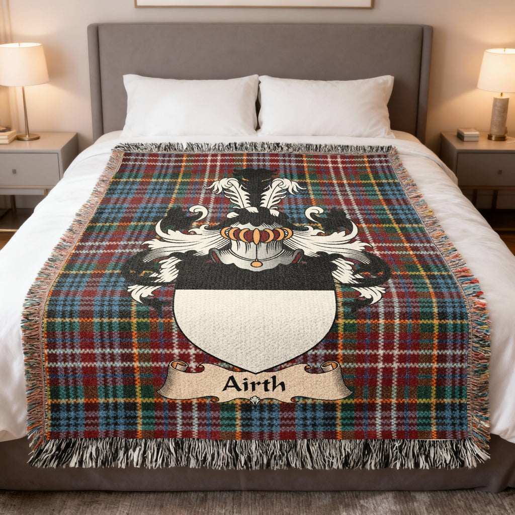 Airth Scottish family crest woven blanket on a Caledonia tartan background, displayed on a bed