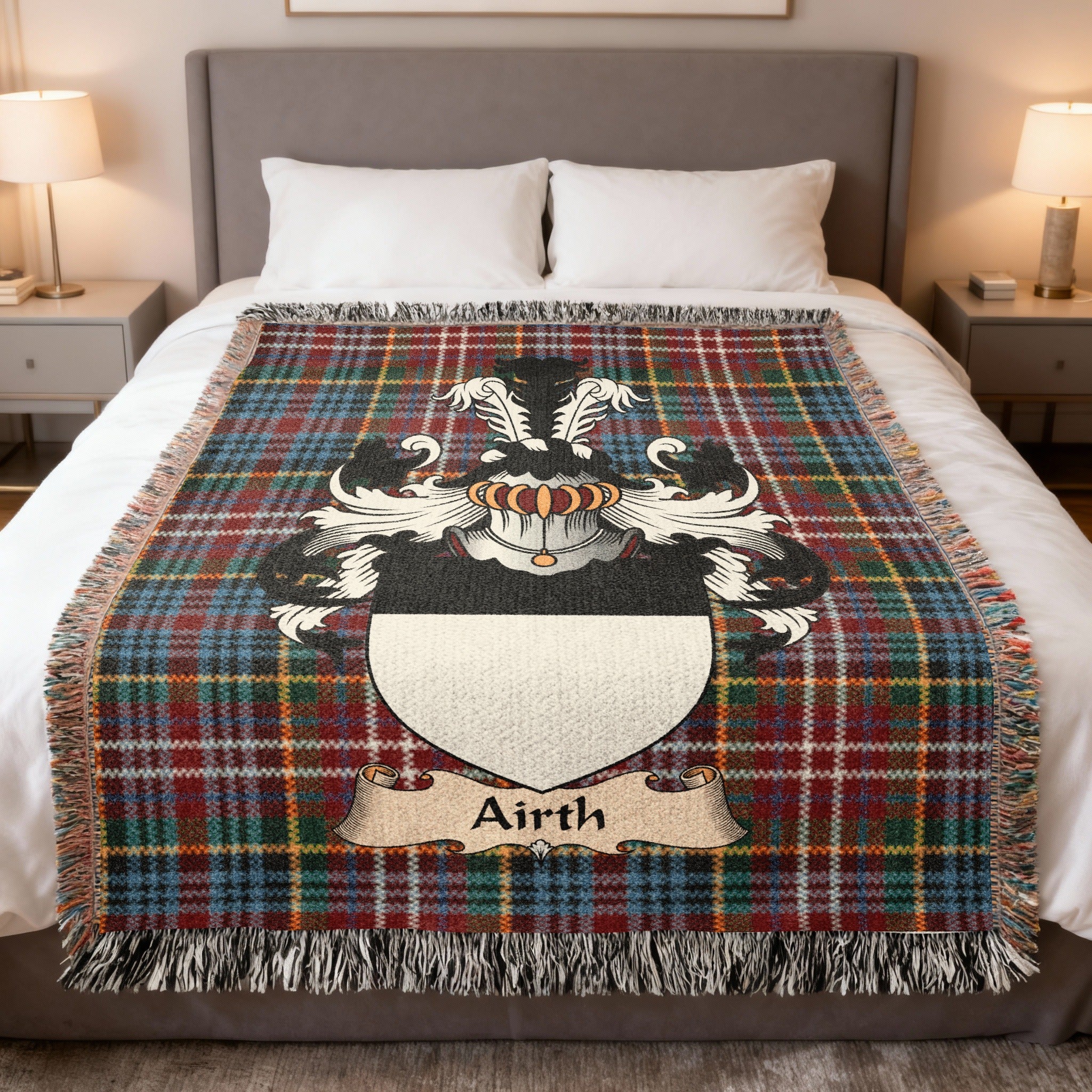 Airth Scottish family crest woven blanket on a Caledonia tartan background, displayed on a bed