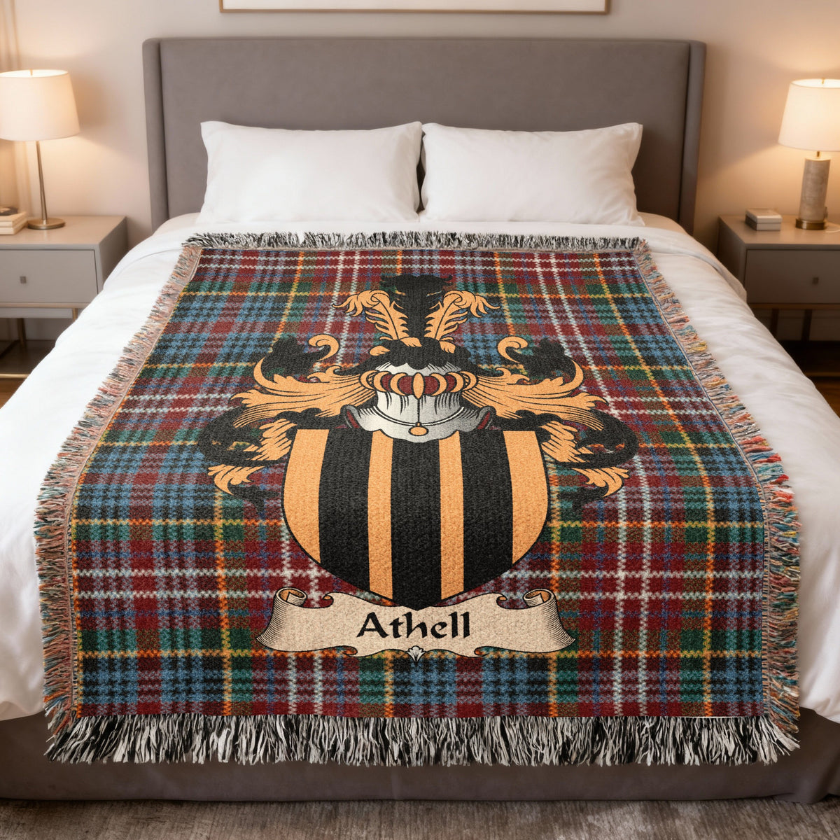 Athell Scottish family crest woven blanket on a Caledonia tartan background, displayed on a bed
