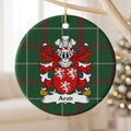 Arod family crest and surname on a round Welsh national tartan ornament, hanging by a gold cord from a pale wooden branch with blurred Christmas lights behind it.