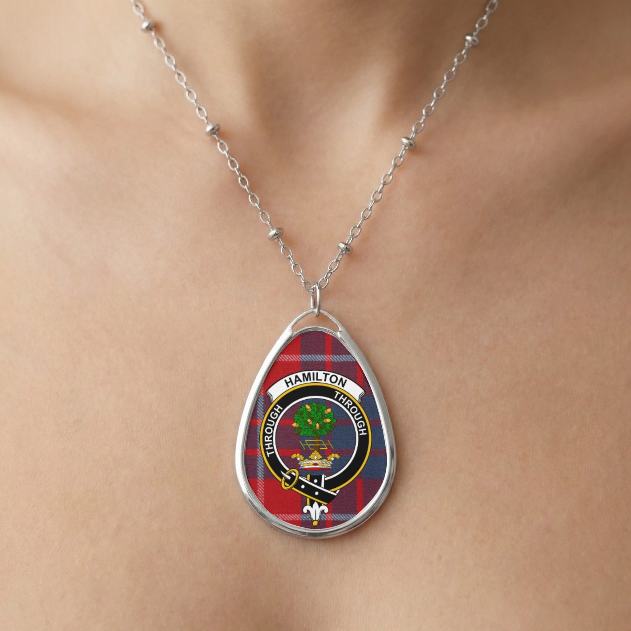 Oval pendant necklace with Hamilton clan crest on red tartan.