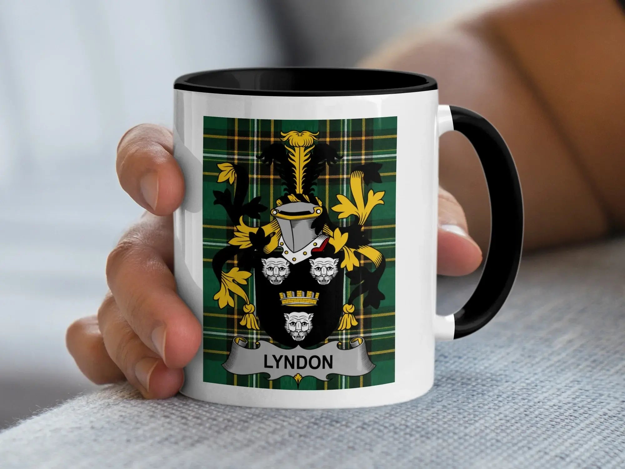 White mug with black rim featuring the Lyndon family crest on a tartan background.