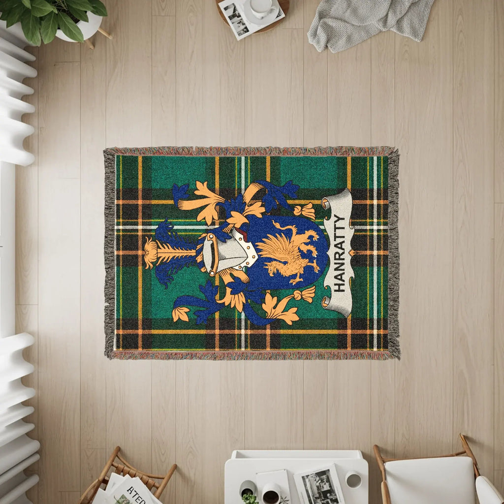 Clan Hanratty crest on a green tartan woven throw blanket.