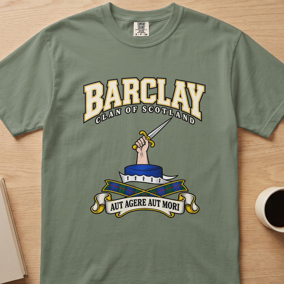 Barclay clan crest with hand holding a sword on a sage green Comfort Colors T-shirt, front view