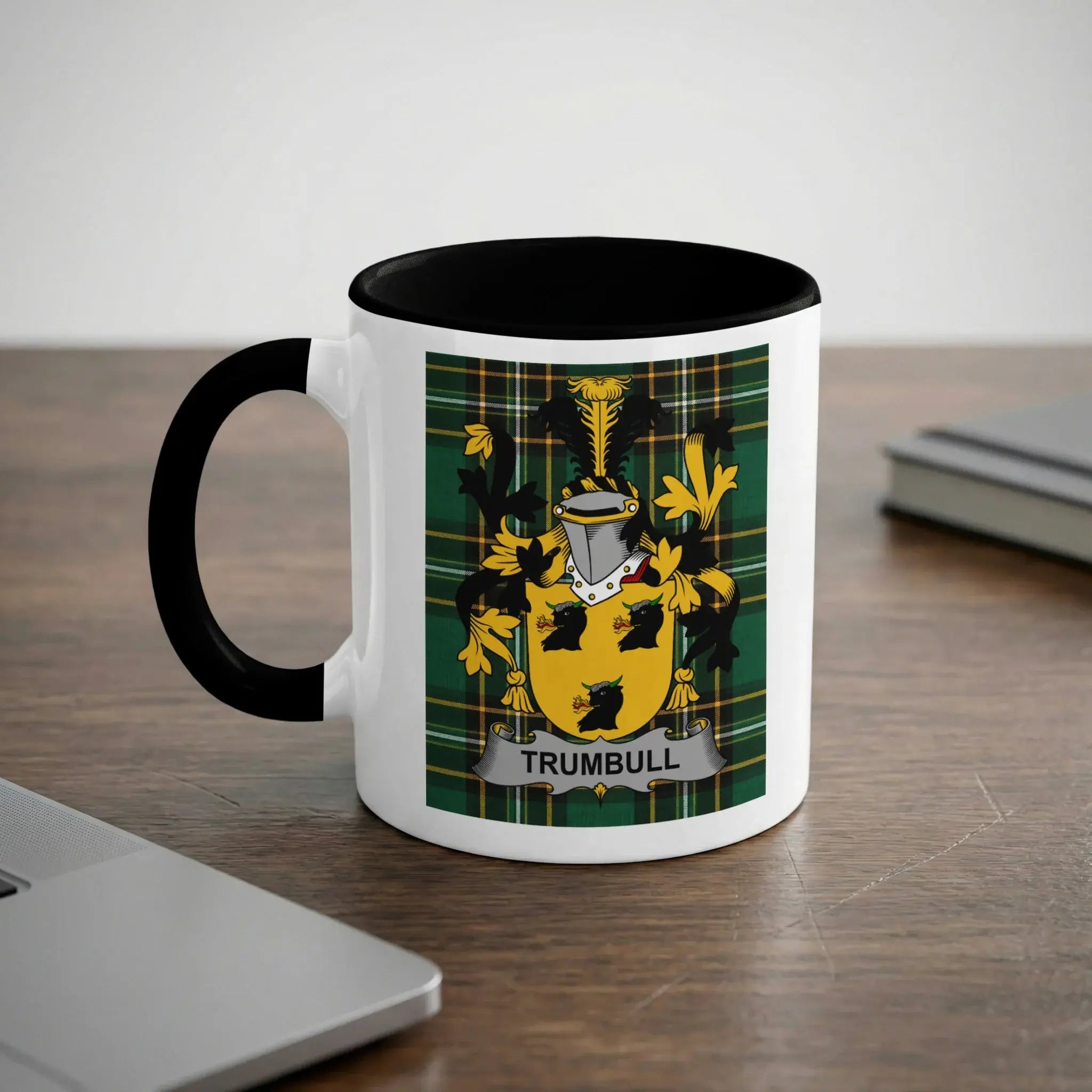 White mug with black rim featuring Trumbull coat of arms on a plaid background.
