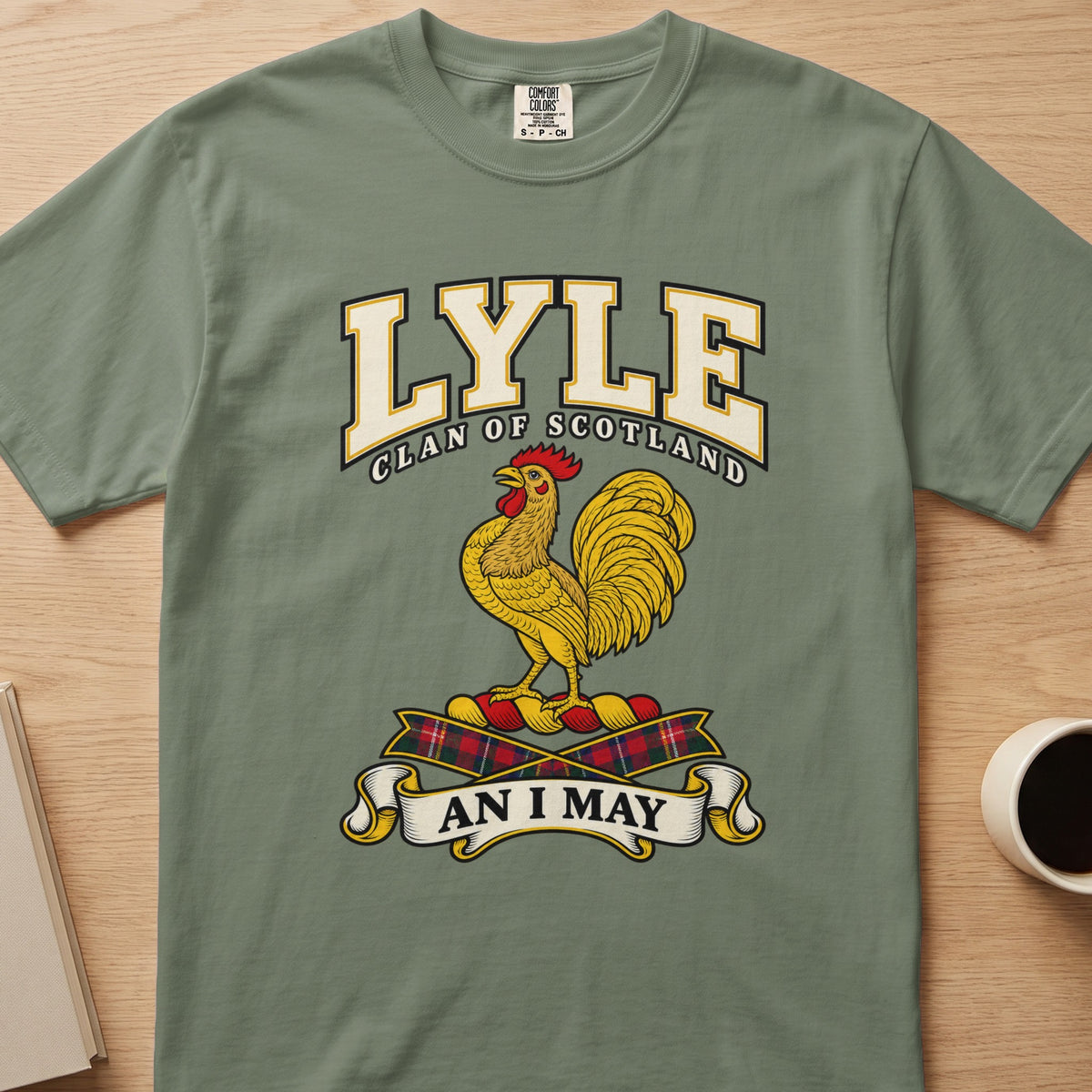 Lyle clan crest with gold rooster on a sage green Comfort Colors T-shirt, front view