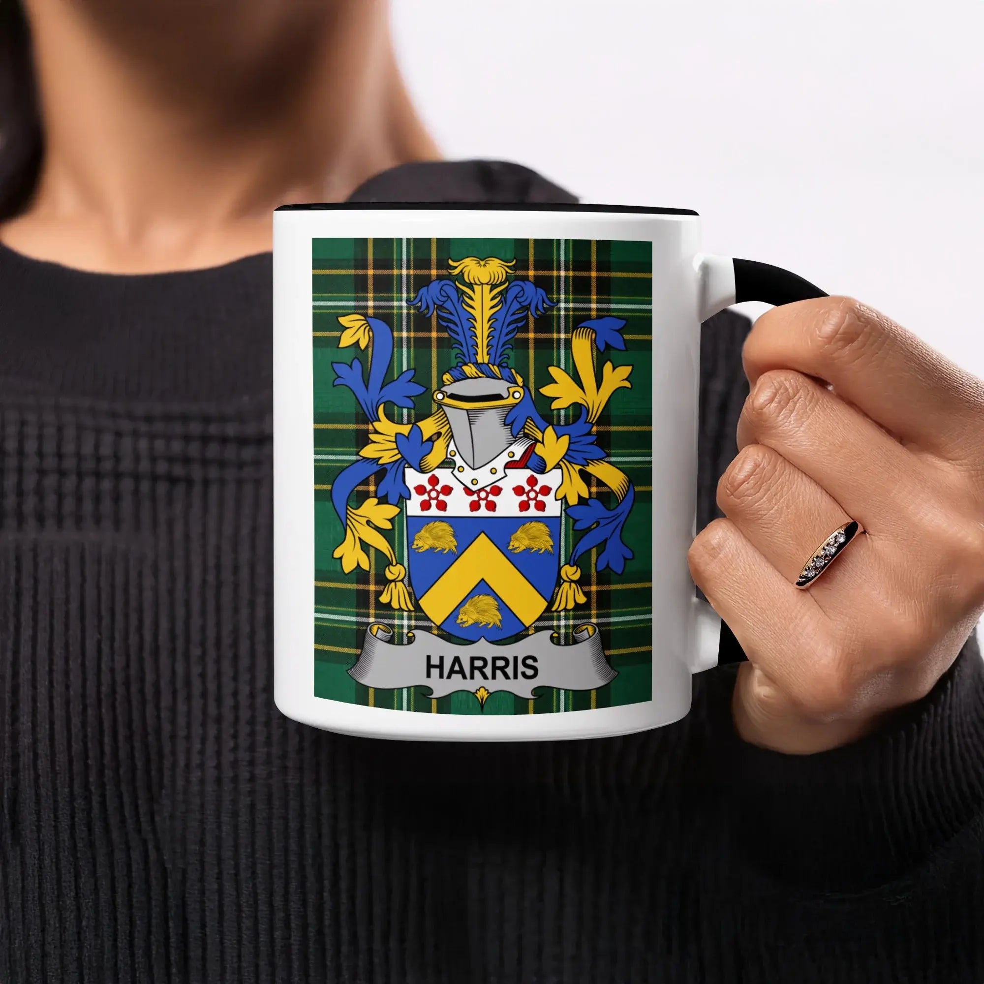 Black mug with Harris family crest on plaid background.
