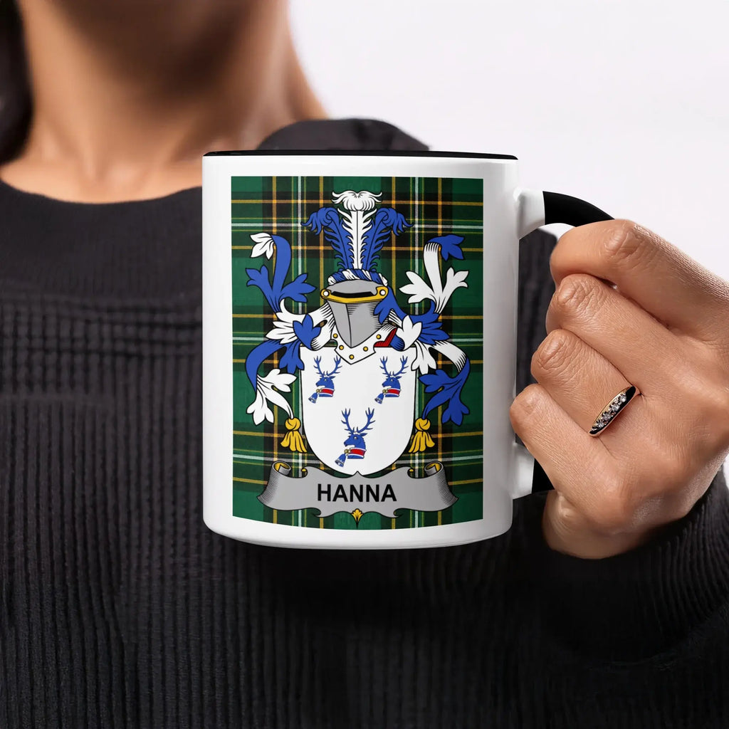 Black mug with "HANNA" coat of arms on a green tartan background.