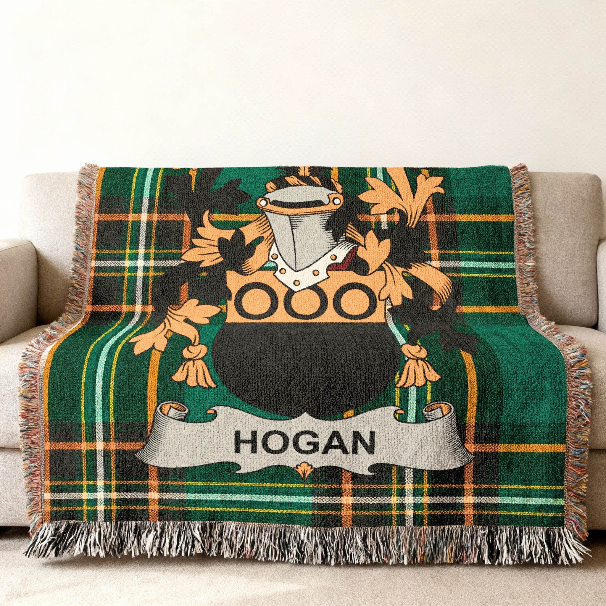 Green plaid throw blanket with Hogan family crest on sofa.